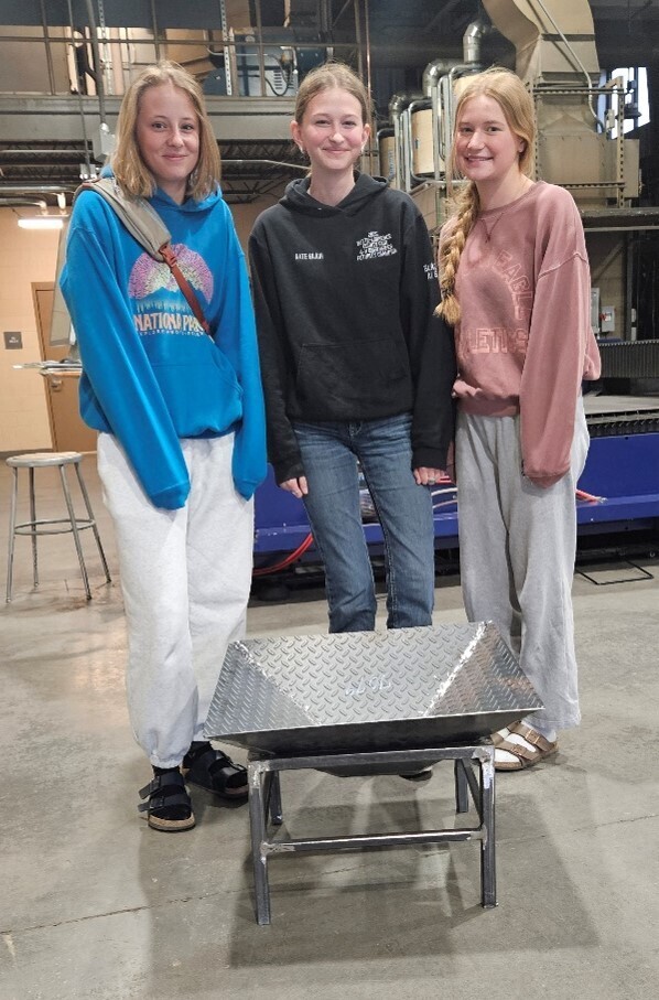 Welding Fabrication Team two Aolani Stone, Kate Blair, and Abbey Clendening (Sophomores) Standing next to their two-piece fire pit