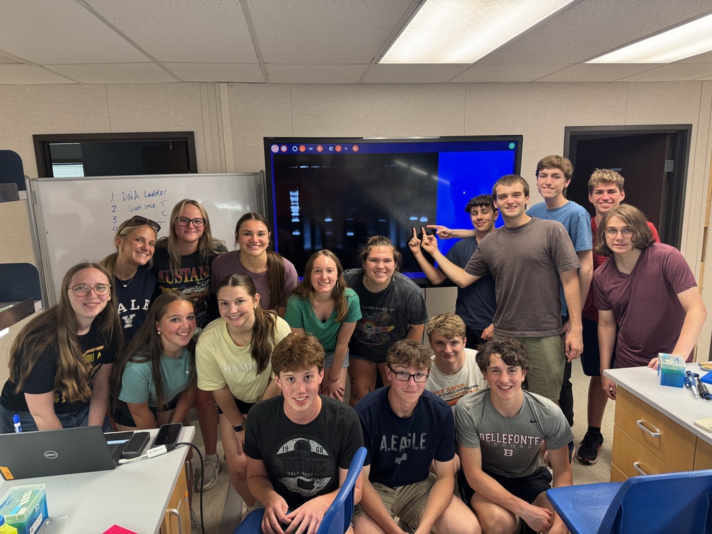 Students posing with science equipment.