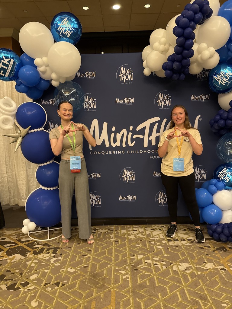 Two high school students posing with Mini Thon poster.