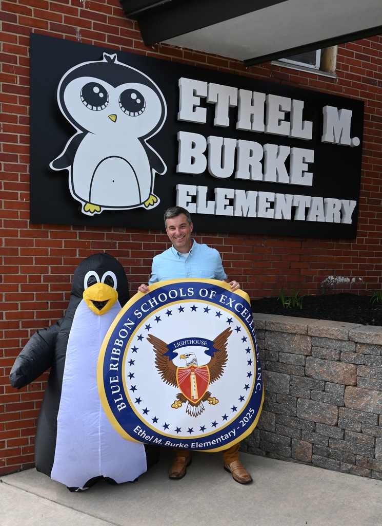 Principal Maguire with the mascot Burkie in front of the school.