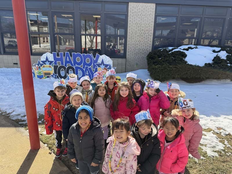 Students smiling outside school building.