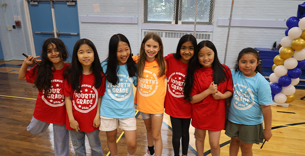 Students smiling together in front of balloons.