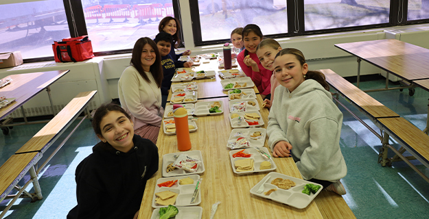 Students sitting at lunch table.