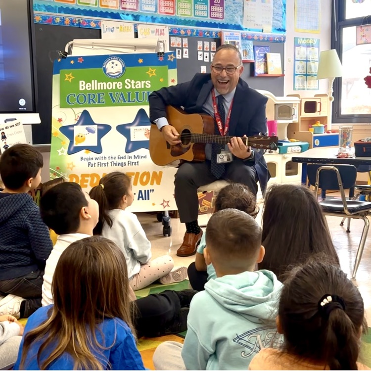 Dr. Joe playing guitar with students 