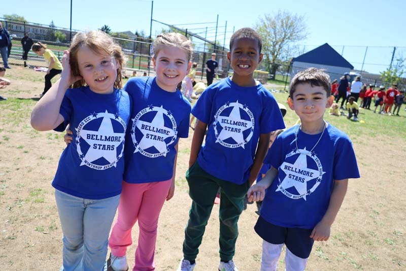 Students smiling outside, dressed in their team's colors.