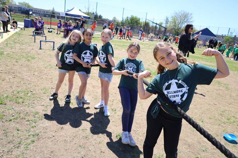 Students smiling outside, dressed in their team's colors.