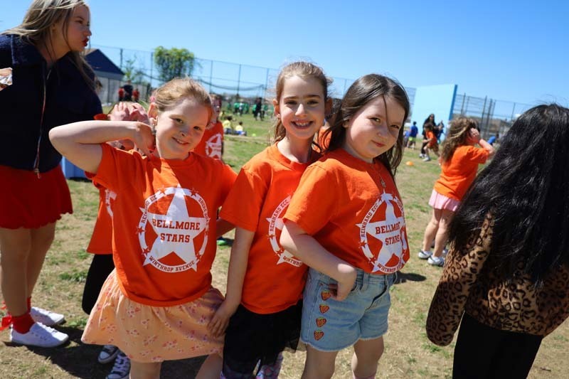 Students smiling outside, dressed in their team's colors.