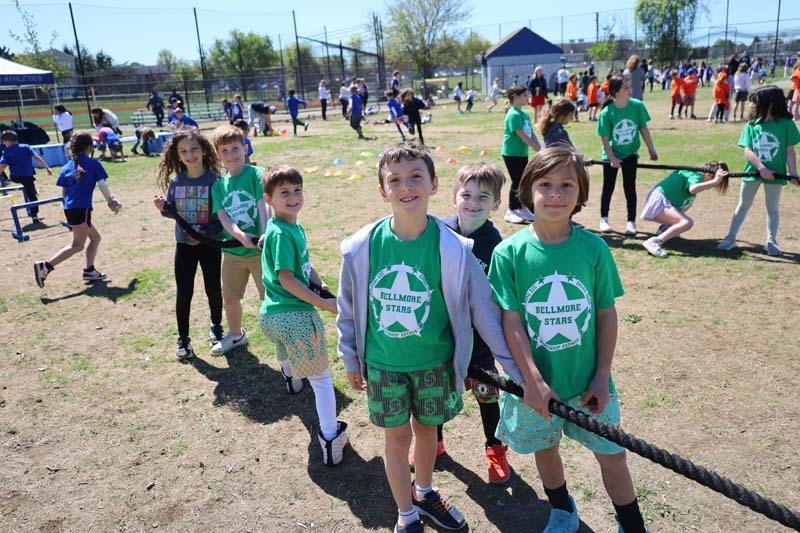 Students smiling outside, dressed in their team's colors.