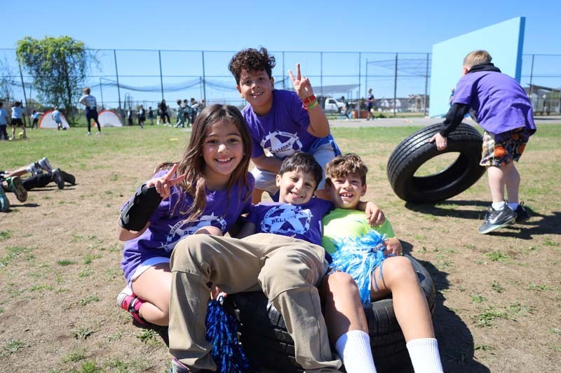 Students smiling outside, dressed in their team's colors.