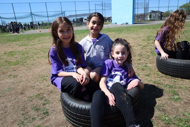 Students smiling outside, dressed in their team's colors.