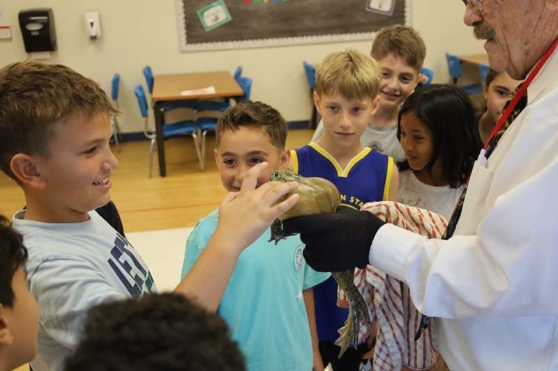 Students touching live frog.