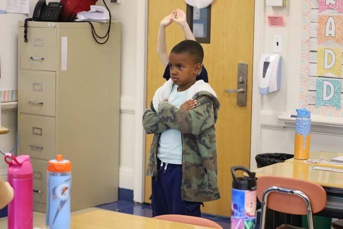 Student standing with arms crossed.
