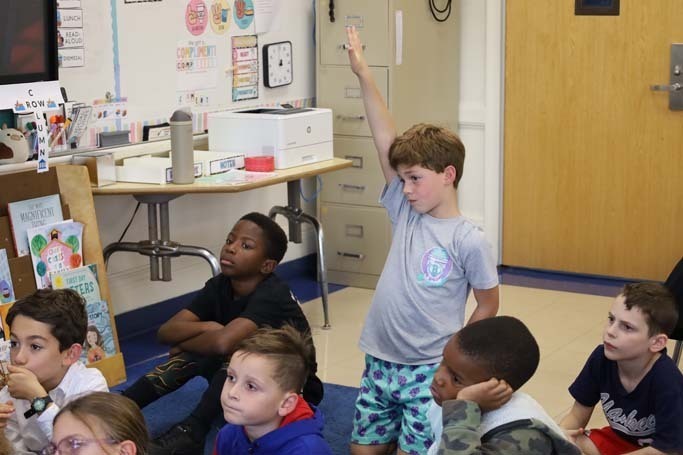 Student raising hand in air.