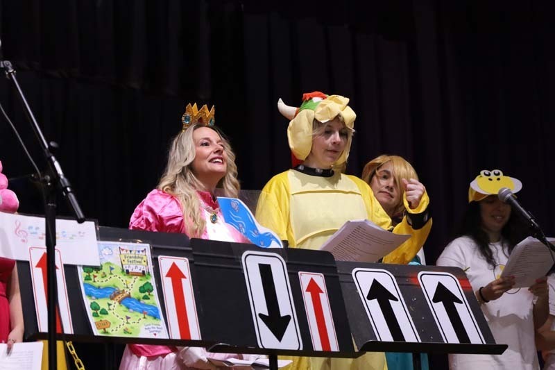 Two adults sitting, dressed as Bowser and Princess Peach.