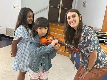 Music teacher Joanna Rocco helped a student pick up a new instrument. 
