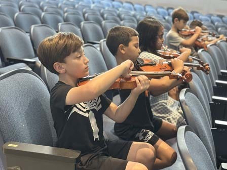 Students learned how to pluck their first notes. 