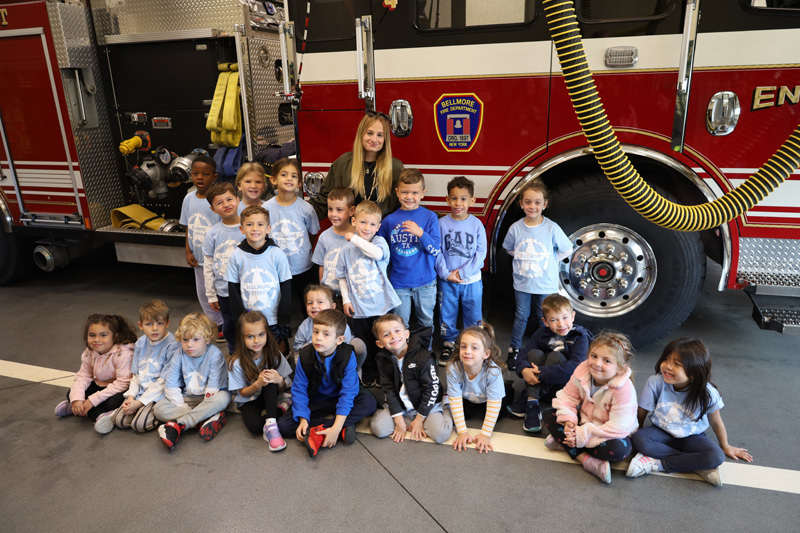 students in firehouse by fire truck
