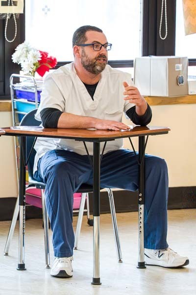 Teacher sitting at desk.
