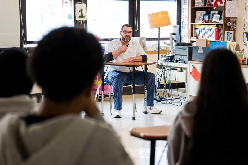 Teacher sitting at desk.