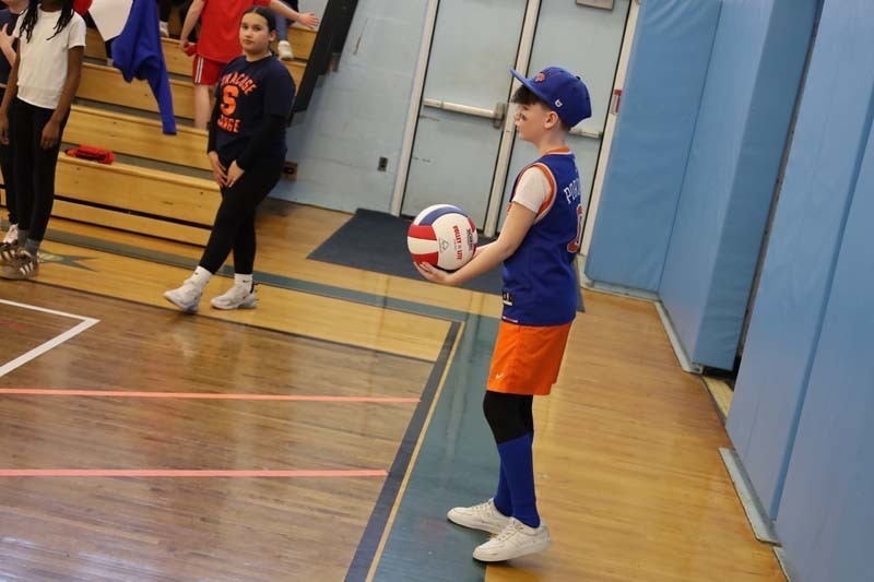 2)	A fierce game of volleyball had students cheering in support of players from the sidelines. 