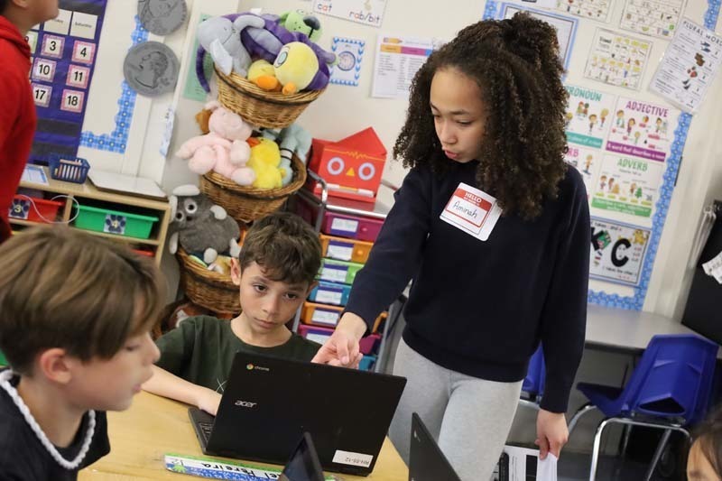 4)	Fifth graders led lively discussions as they assisted their younger peers. 