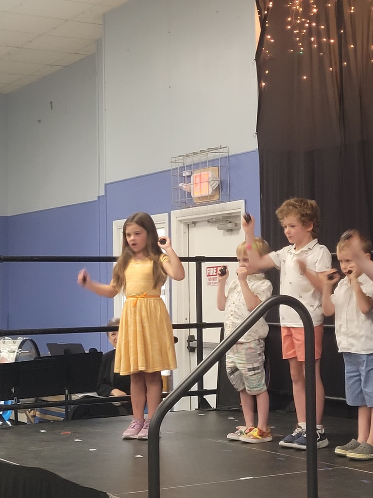 students at concert singing and playing instruments