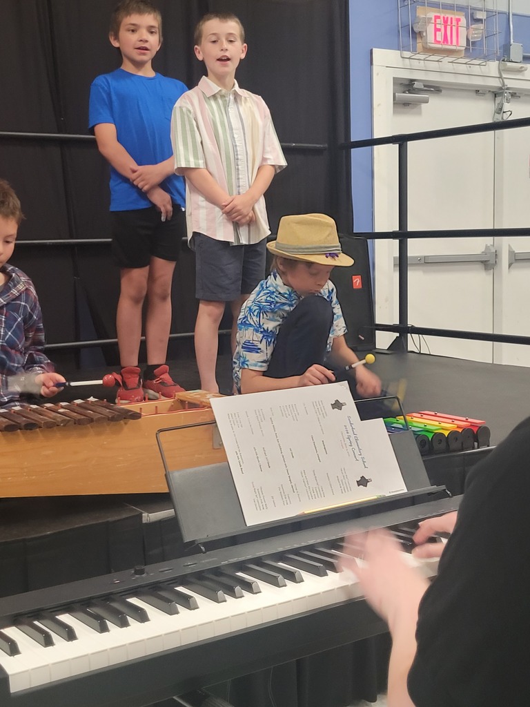 students at concert singing and playing instruments