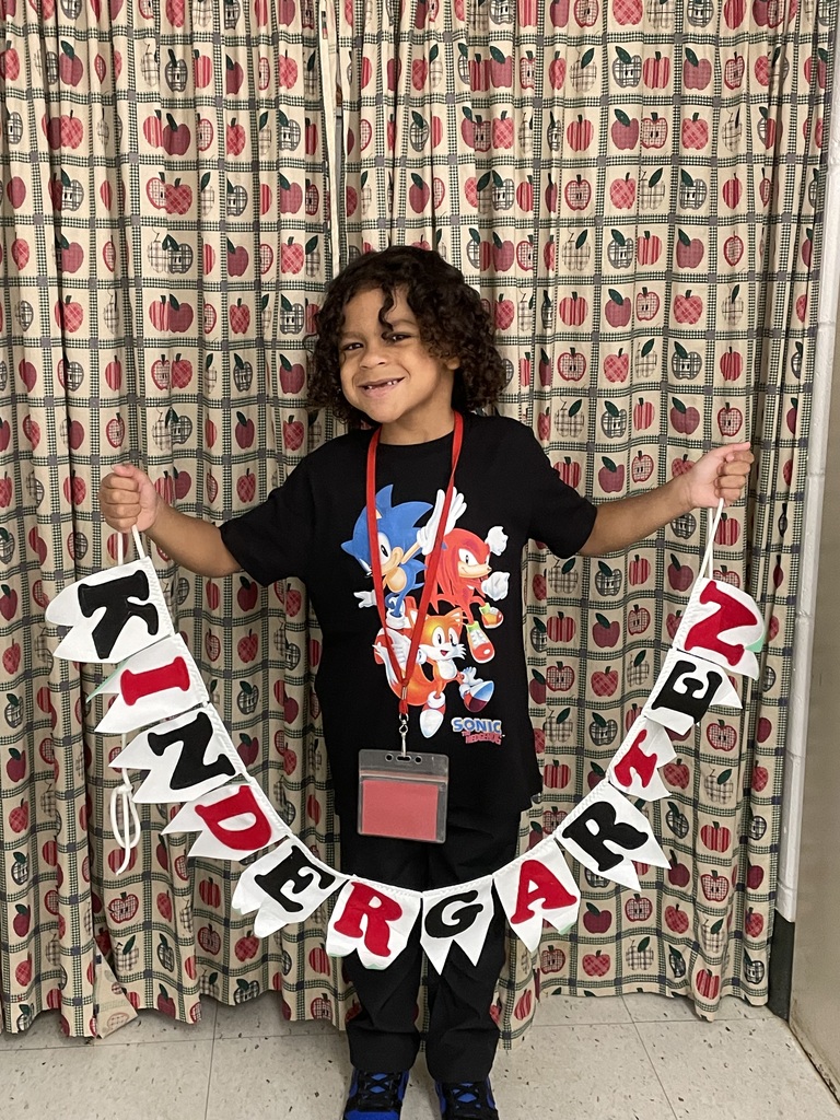 Student posing with Kindergarten sign