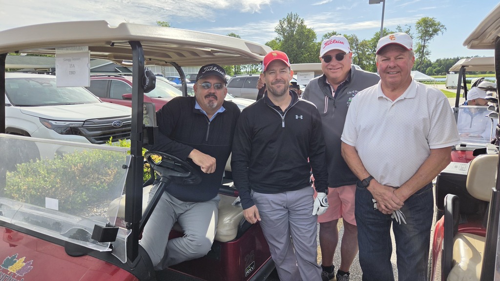 Image from the golf outing - a group of four golfers by their cart