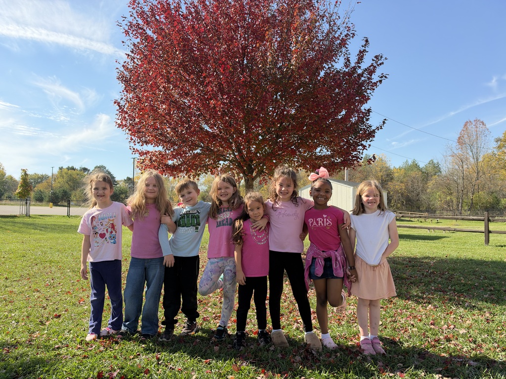Children posing in front of a tree