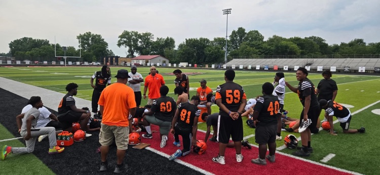 Varisty football team huddle on field