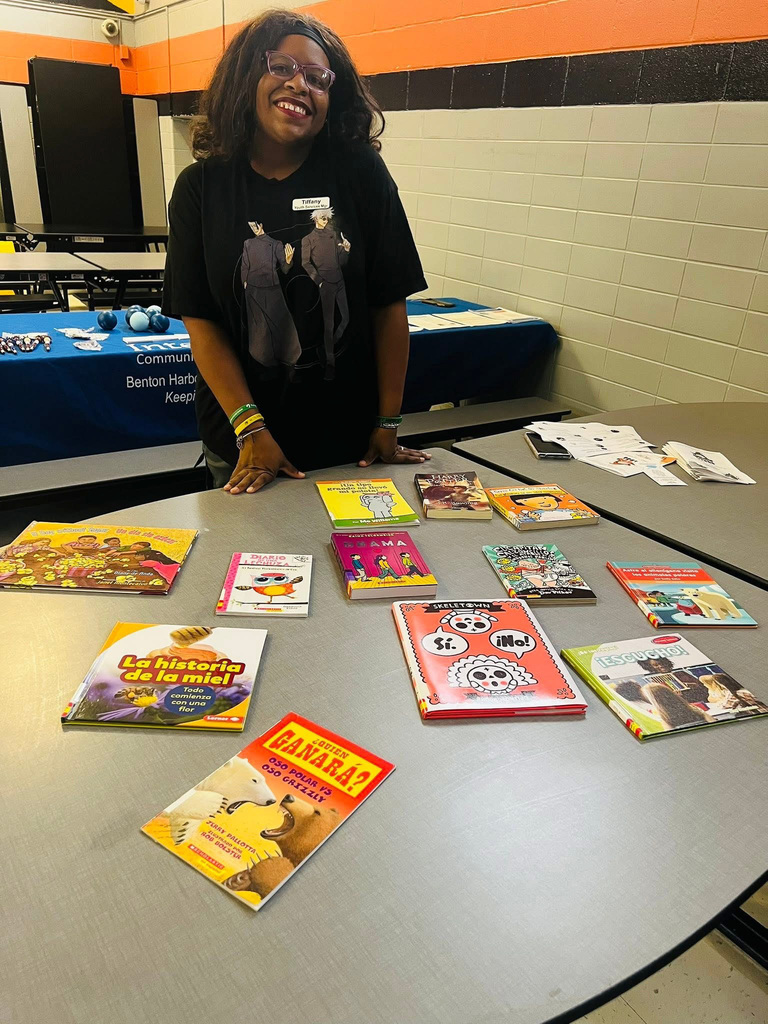 Woman smiling at BH Public Library Table with Spanish and Bilingual books 