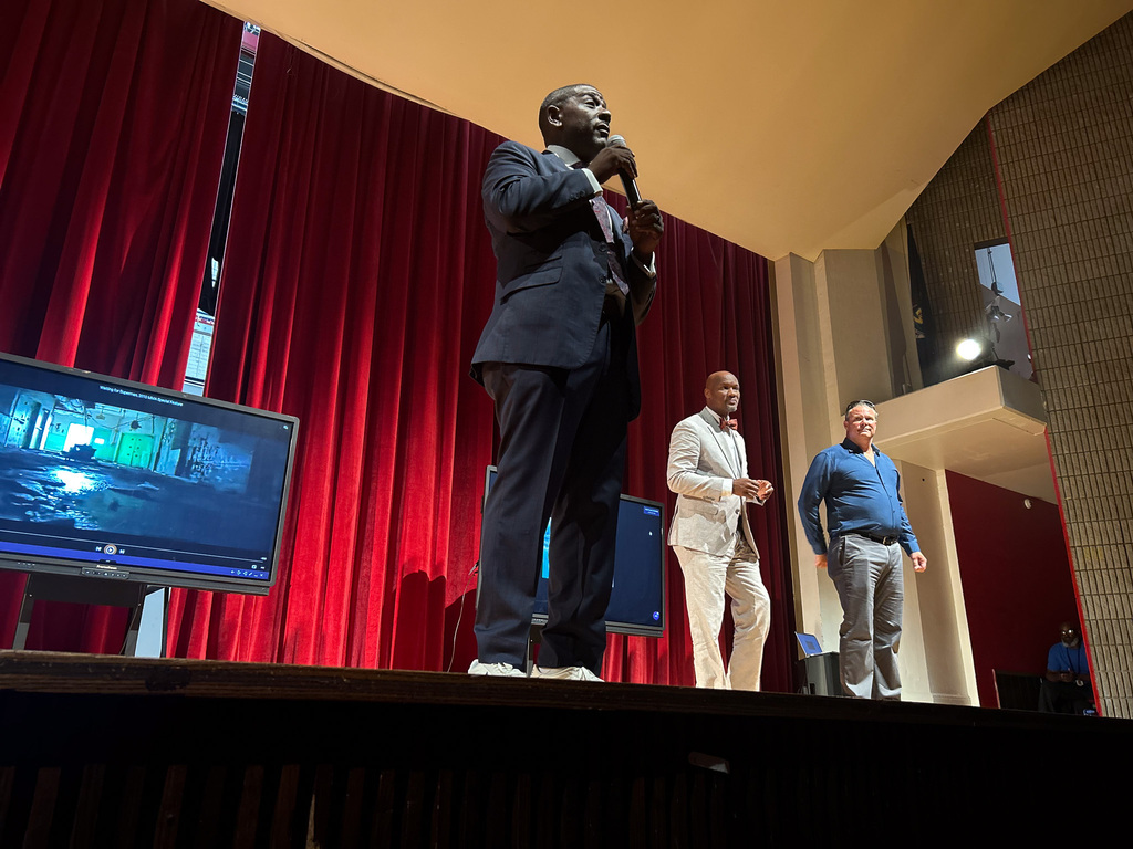 Presenter speaking to BHAS staff from an auditorium stage during a district professional learning event.