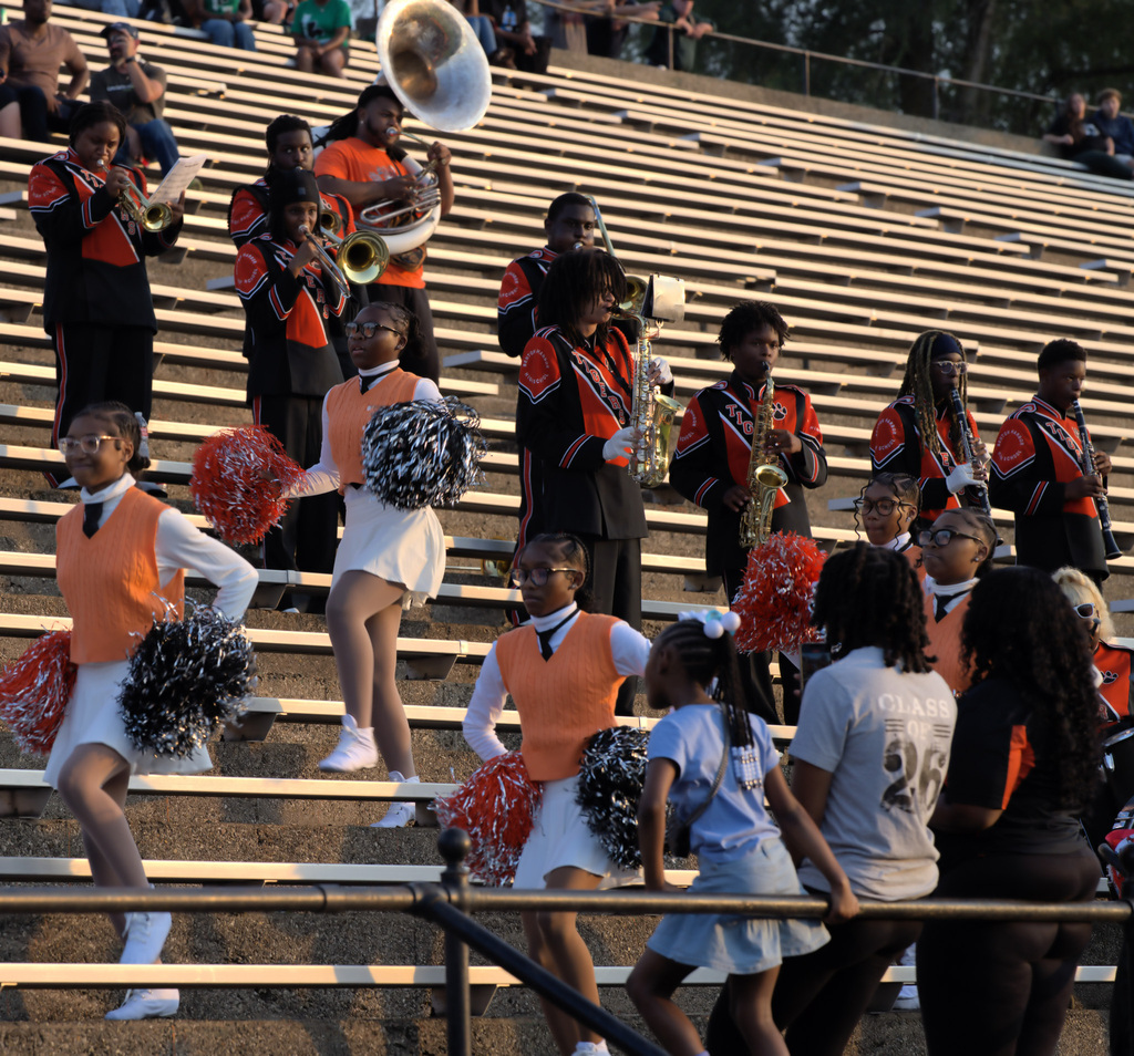 Benton Harbor marching band performing together in the stadium stands during the football game.