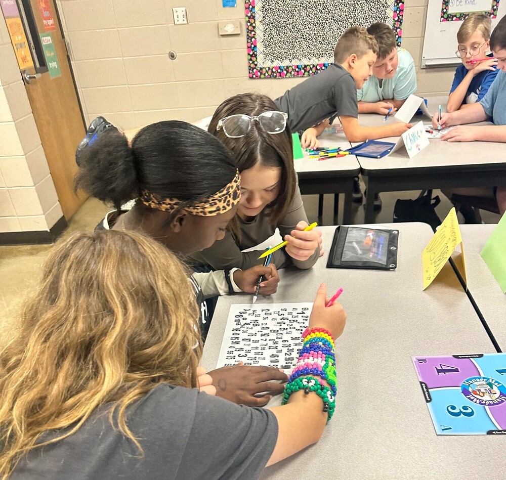 Three students using Kagan strategies to work together on a group project