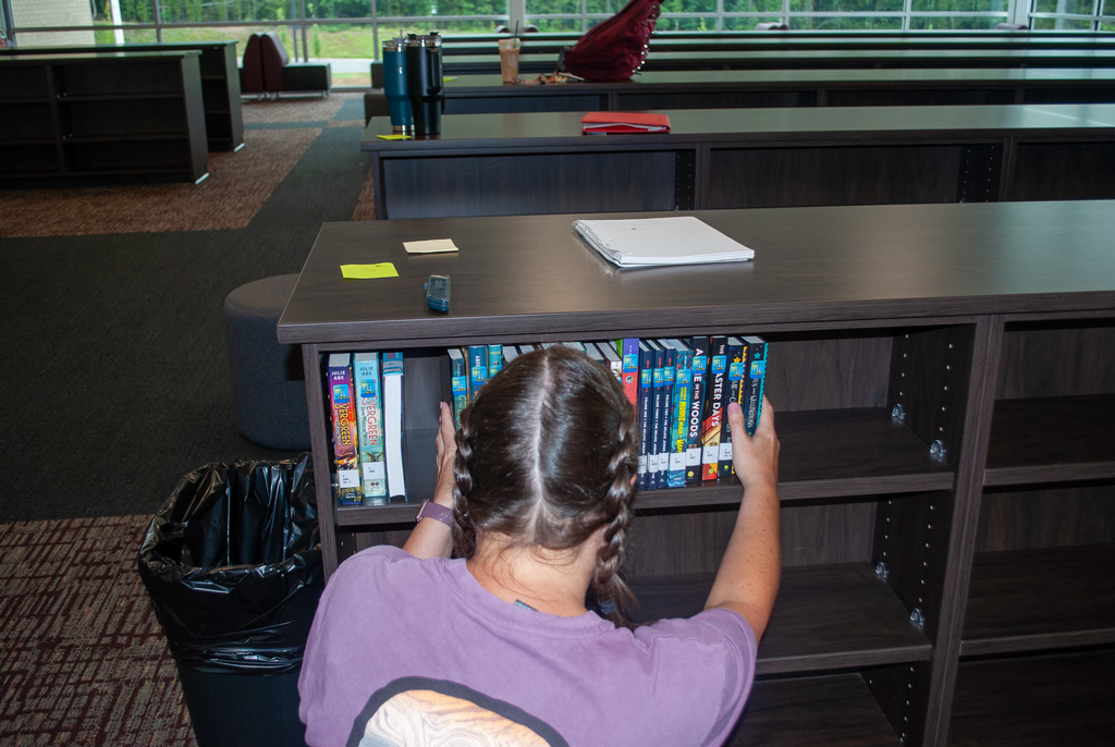 Mrs. Spadaro fixing the bookshelves