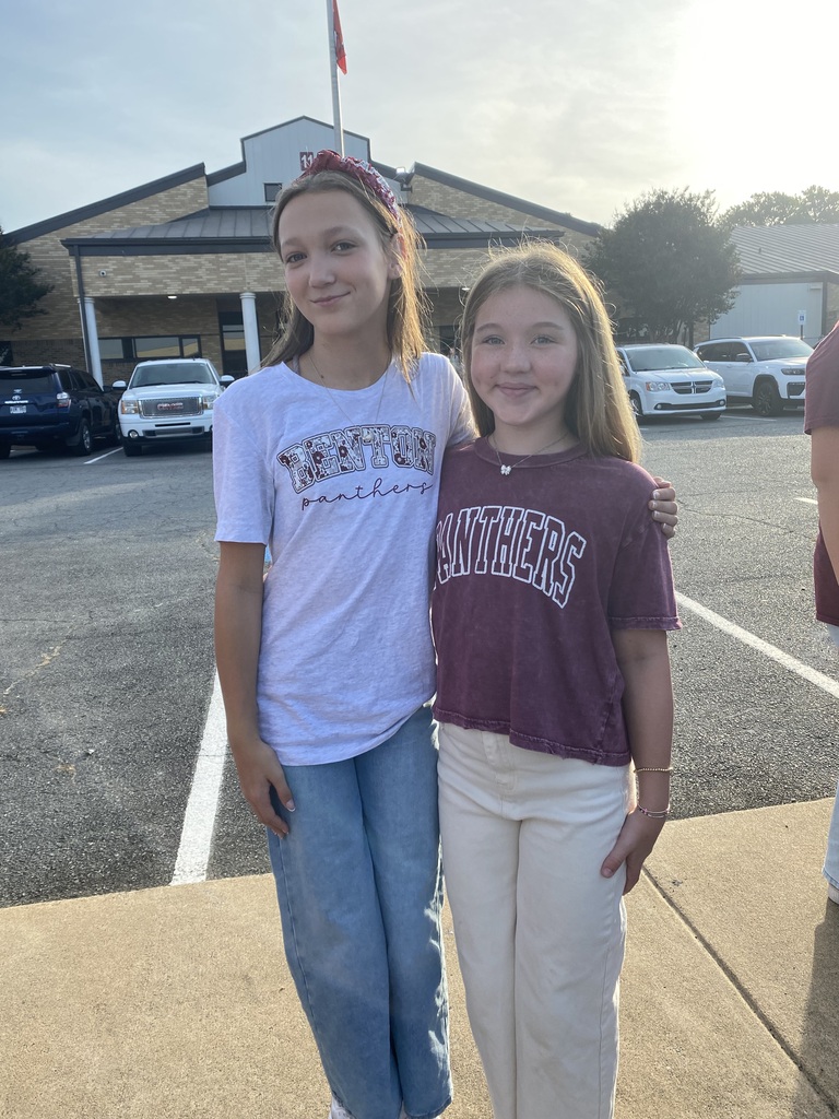 Two students in Benton gear are posing for the camera before the Senior Parade