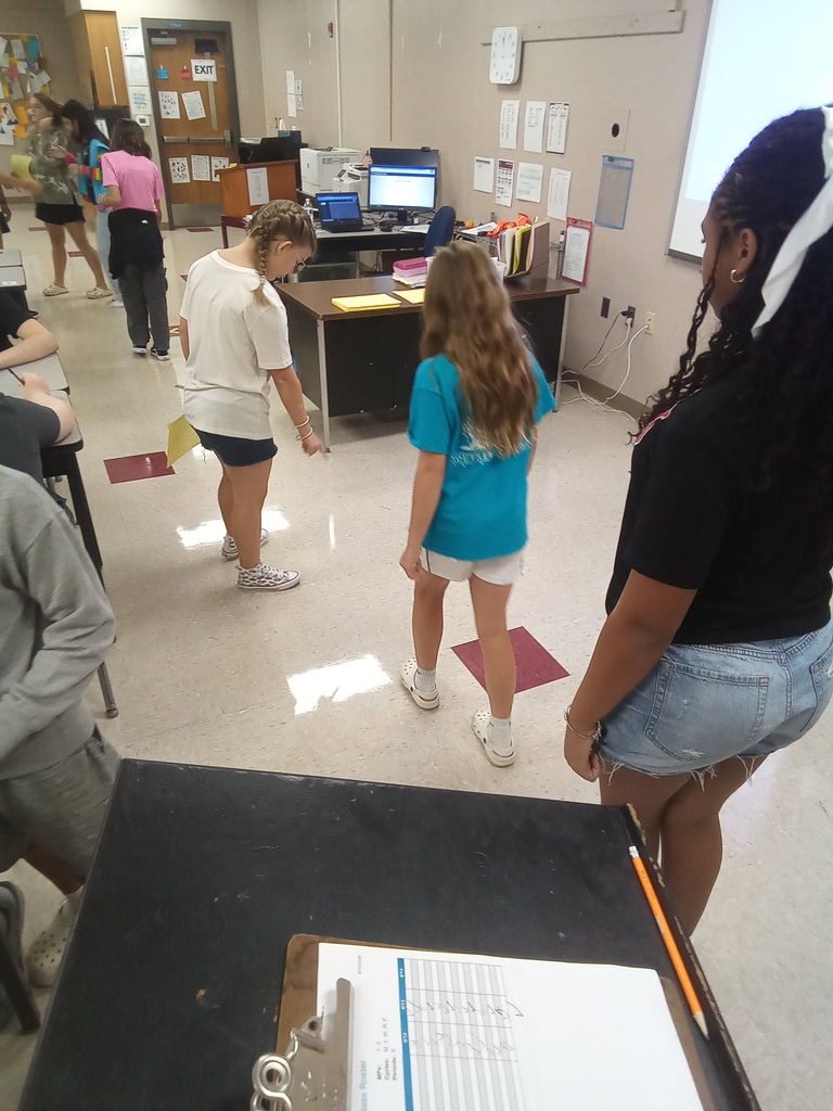 Two students are walking through the classroom participating in the activity described in the post