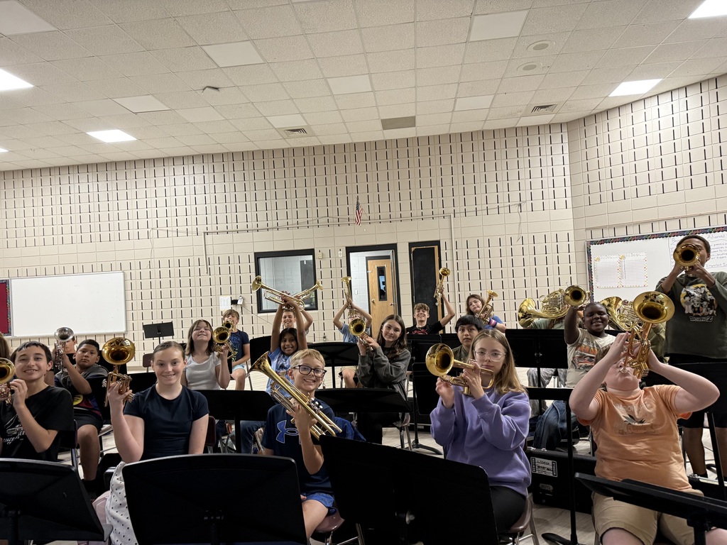 Beginning trumpet and french horn students are learning how to hold instruments for the first time.