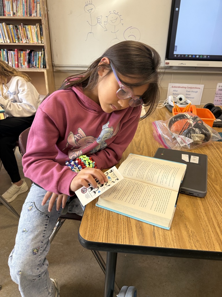 A student is sitting at their table reading the book Wonder in their ELA class