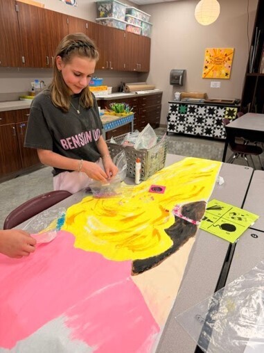 A student working on painting part of the Dolly Parton Memorial