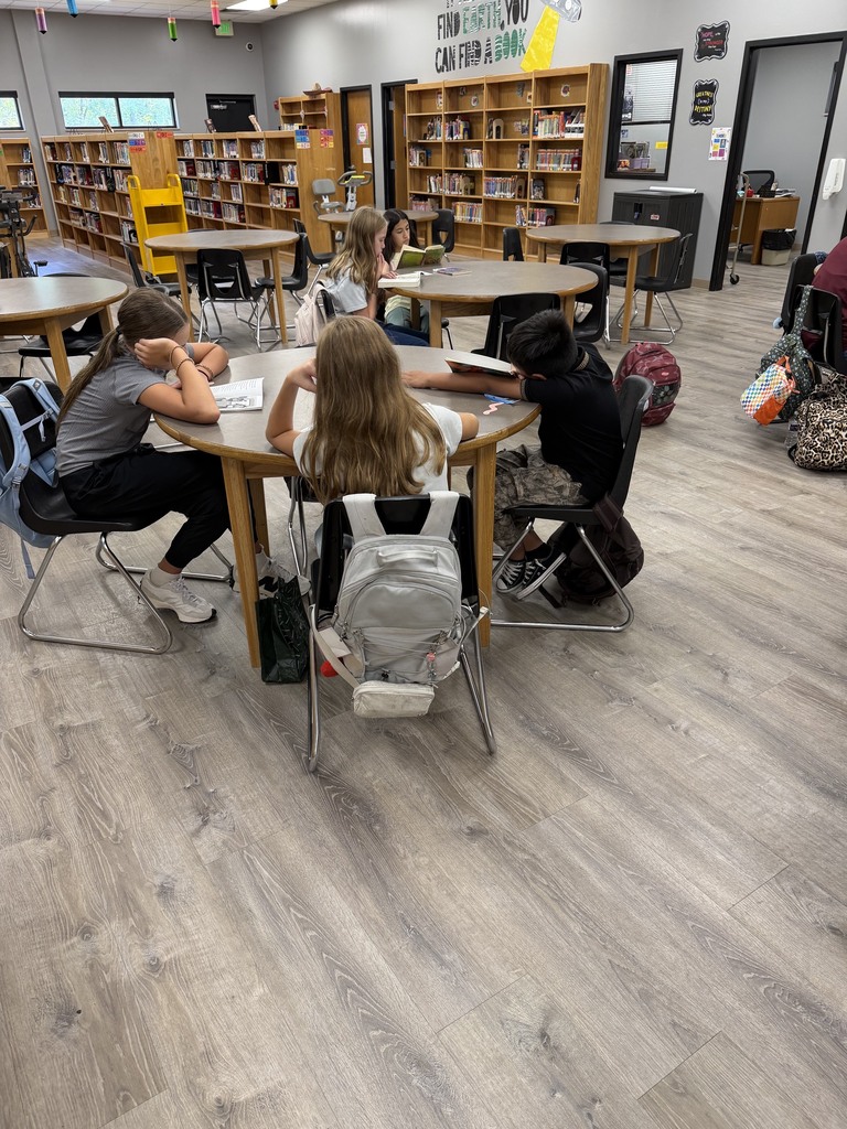 students reading quietly at tables in the library