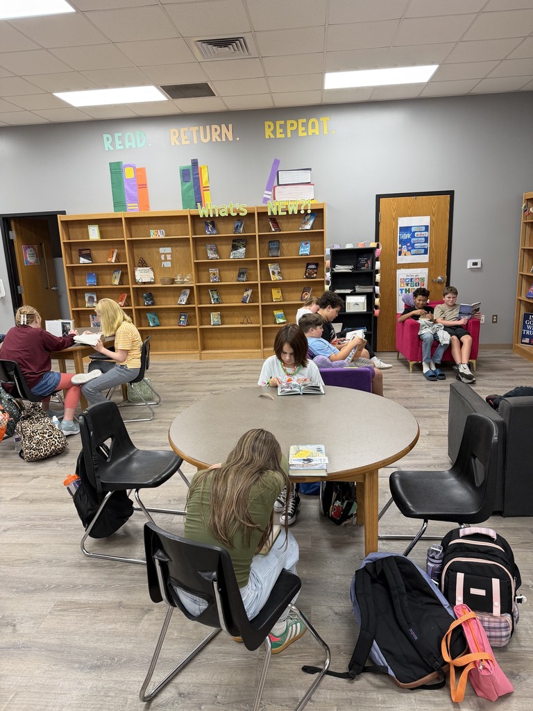 Students reading quietly at tables in the library
