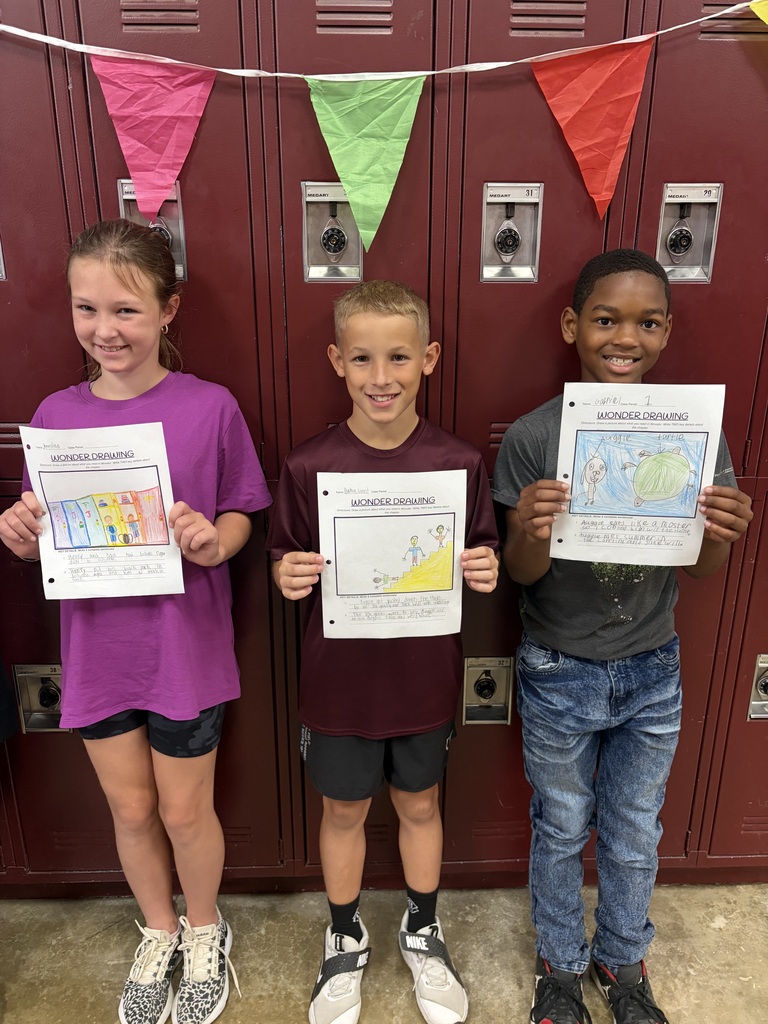 Three students are holding papers