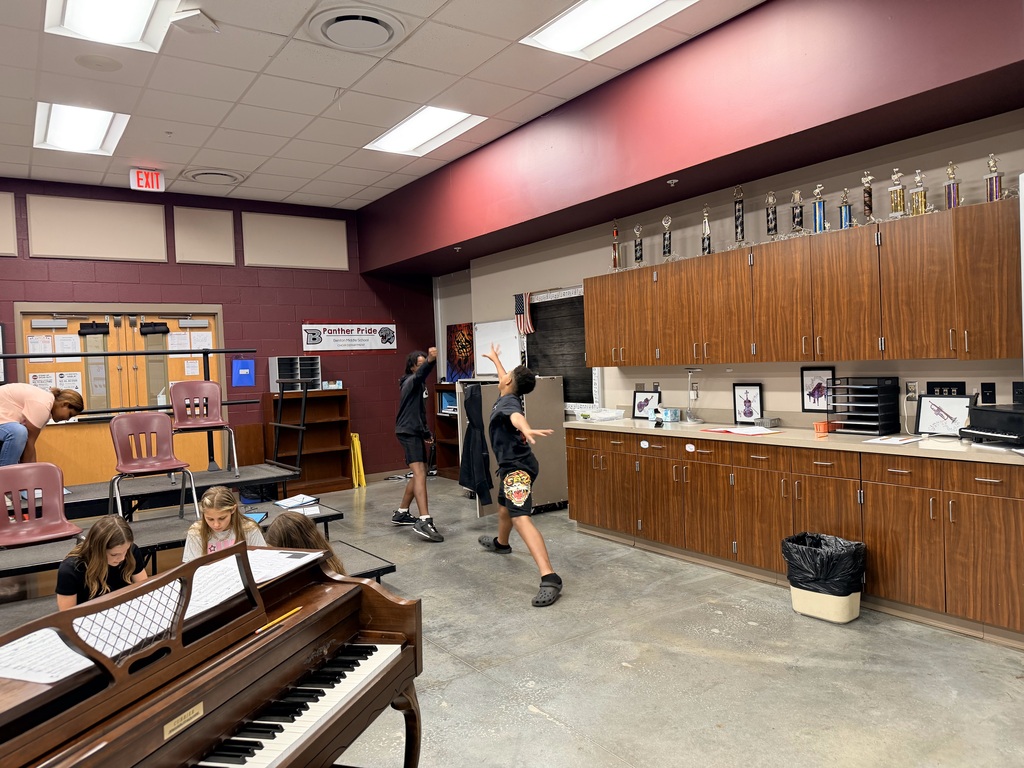 Students around the choir room playing rock, paper, scissors that has been adapted into a rhythm game