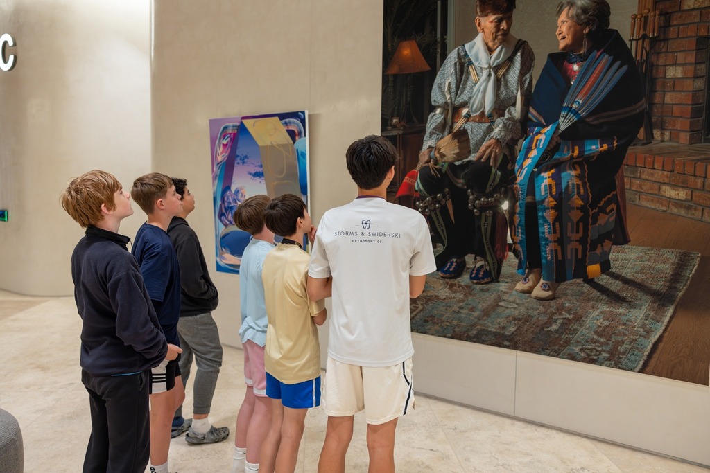 students standing and looking at art