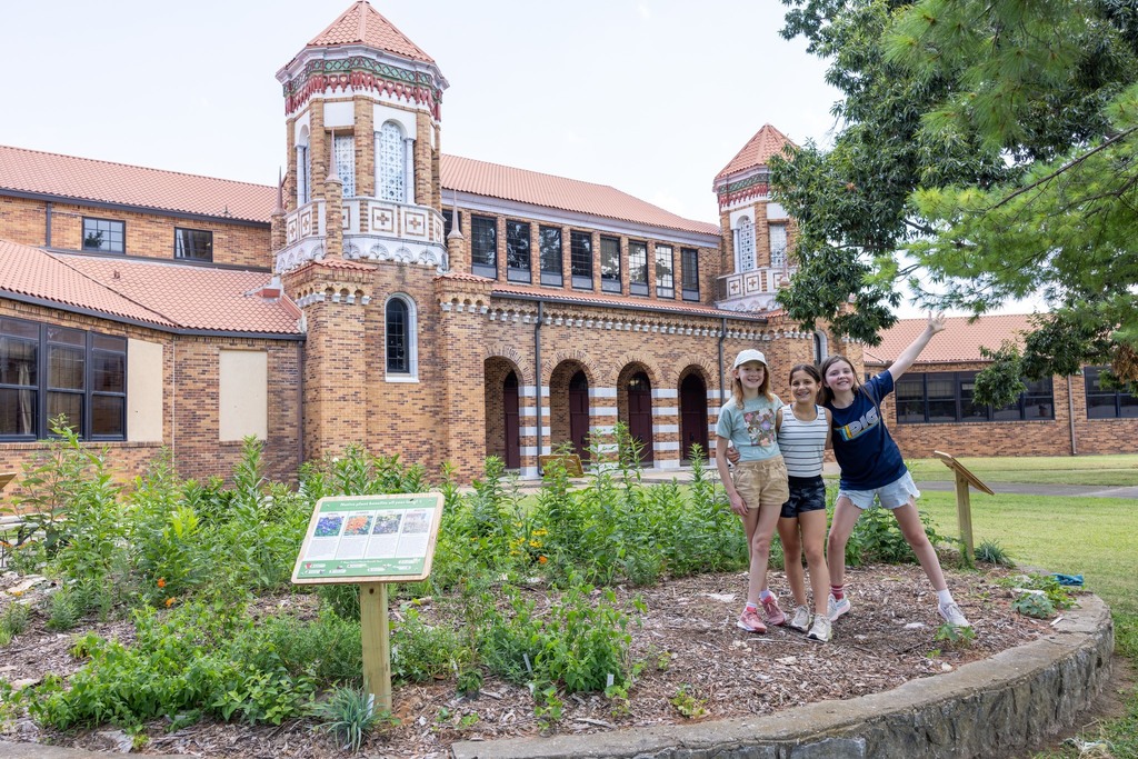 Three students standing at the Old High Middle School butterfly garden