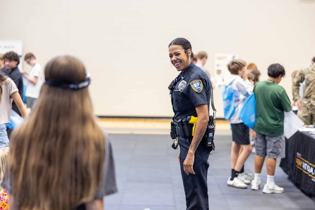 Police officer interacts with student at career fair event