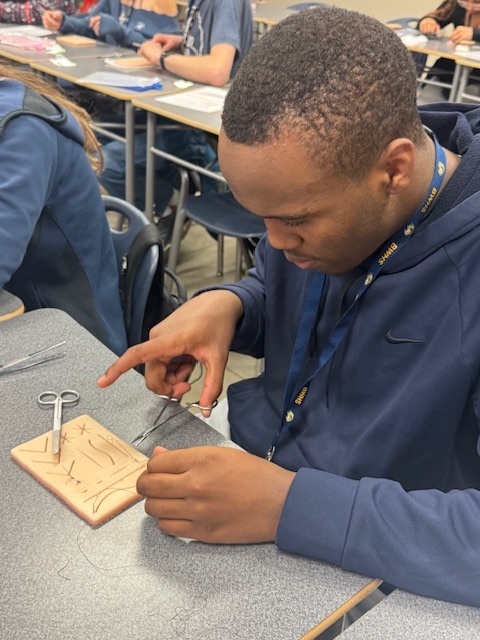 Foundations of Healthcare students practice sutures in a live lesson.