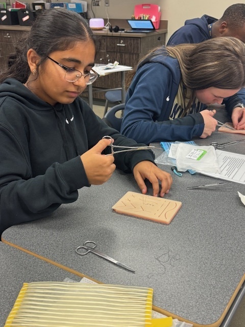 Foundations of Healthcare students practice sutures in a live lesson.